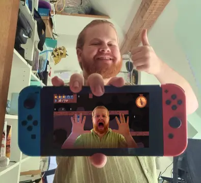Sugarcyube holding up the Nintendo Switch with Escape The Rewind on screen, thumbs up